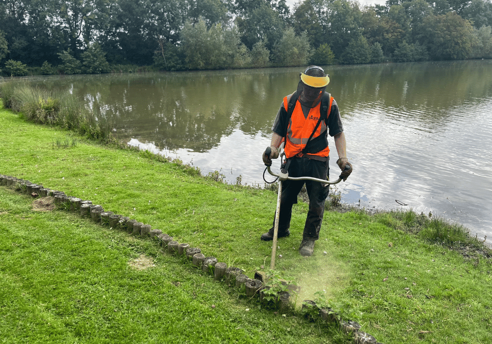 Salarié en insertion des espaces verts qui désherbe